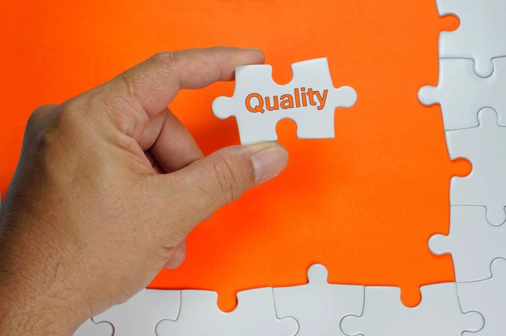 A person holding a puzzle piece that says quality.