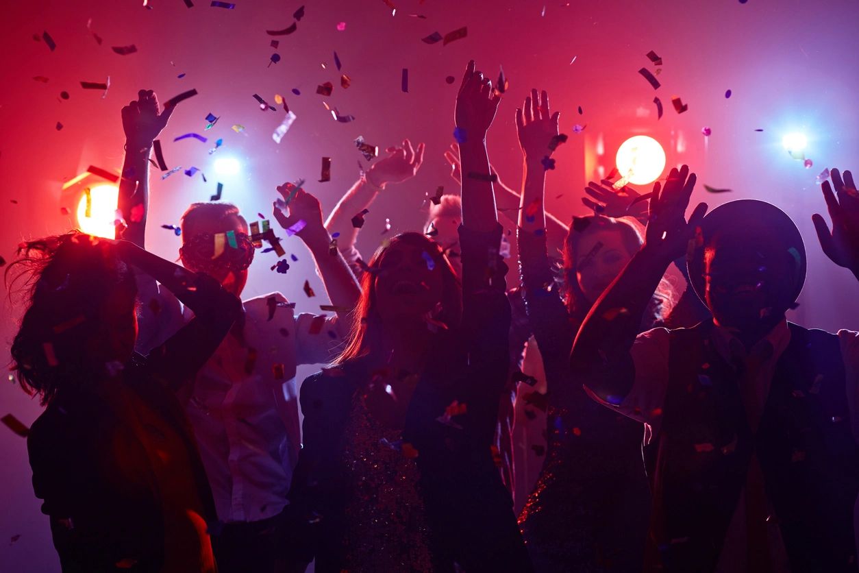 A group of people in a room with lights on.