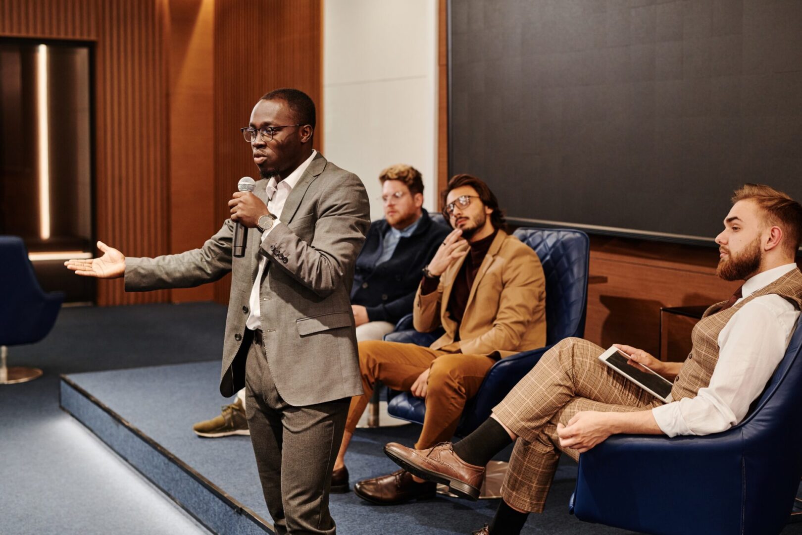 A man in a suit is speaking to people